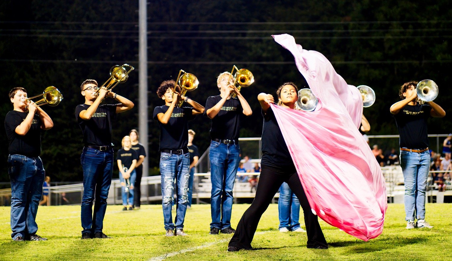 Color guard member Emily Roman performs a solo accompanied by the low brass section of the Proud Blue Band during halftime Friday. [more action and atmosphere from Bud Moody]